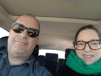 photo of a man and a woman sitting in the front seat of a car